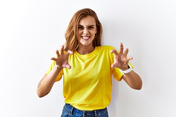 Sticker - Young brunette woman standing over isolated background smiling funny doing claw gesture as cat, aggressive and sexy expression