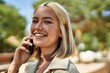 © Krakenimages.com - Young blonde girl smiling happy talking on the smartphone at the city.