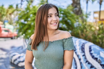 Wall Mural - Young hispanic girl smiling happy standing at the city.