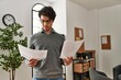 © Krakenimages.com - Young hispanic businessman concentrate reading paperworks at the office.