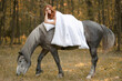 Red-haired girl on a horse under the covers