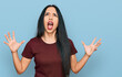 © Krakenimages.com - Young hispanic girl wearing casual t shirt crazy and mad shouting and yelling with aggressive expression and arms raised. frustration concept.