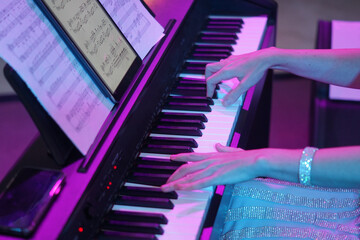 the hands of a musician play the piano