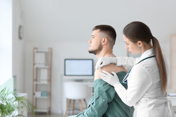 Poster - Doctor applying plaster onto shoulder of young man in clinic