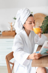 Wall Mural - Young woman drinking juice at home