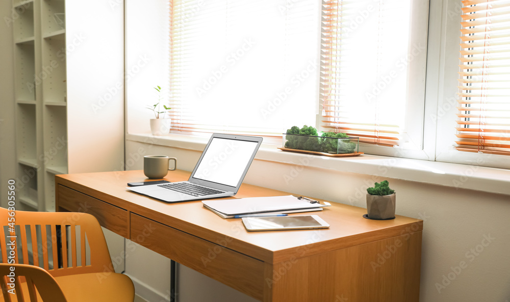 Comfortable workplace near window in modern room