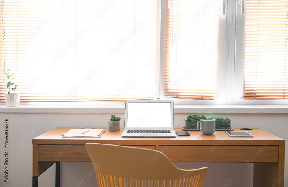 Comfortable workplace near window in modern room