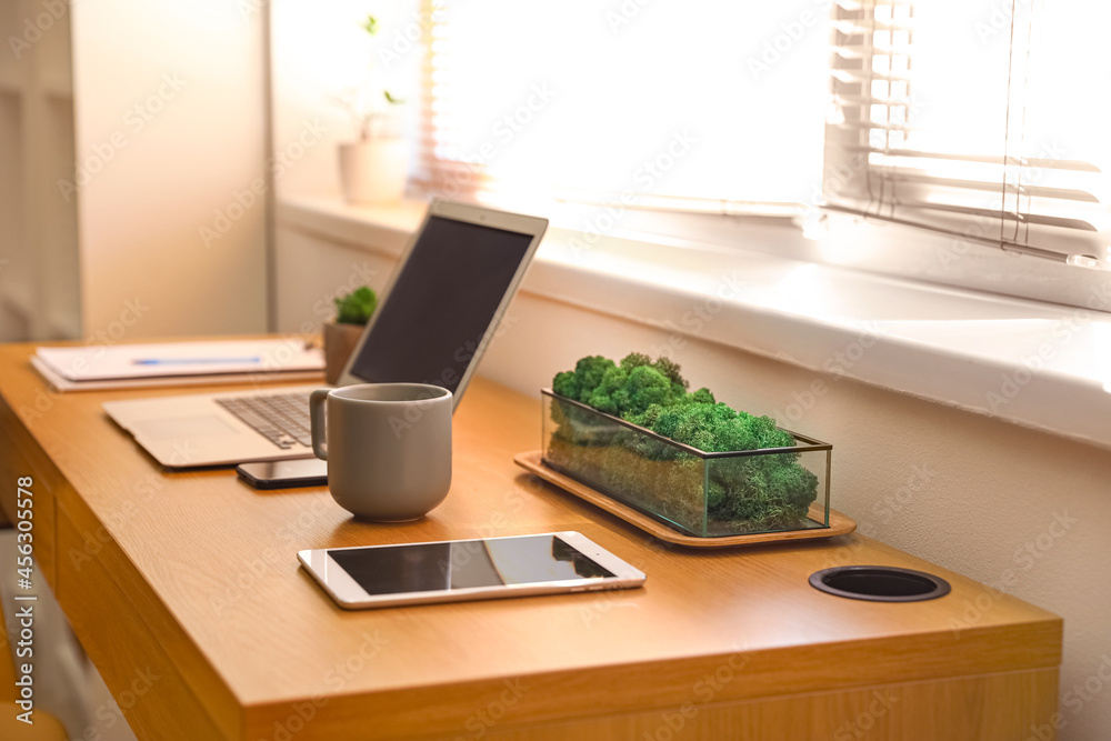 Comfortable workplace near window in modern room