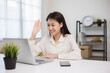 © Chanakon - Young asian woman using laptop chatting video conference online sitting in living room at home. Business Woman looking at screen Meeting on social media live steam. Work, learning from home.