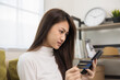 © Chanakon - Shopping online. Young asian teenage girl input the serial number of credit card to smartphone for shopping payment. Buy item online delivery at home. Smiling female feeling happy.
