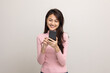 © Chanakon - Pretty young asian woman using smartphone standing on isolated white background feeling happy. Shopping online payment with mobile phone. Excited and surprised female holding cellphone.