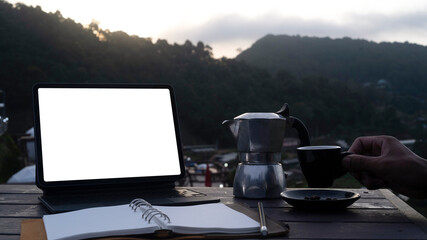 Fototapete - Computer laptop, notebook and coffee cup on wooden table with nature mountains view.
