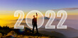 Silhouette of man hands up to challenge 2022 on mountain hill. Happy new year 2022. Man Silhouette at sunset, sunrise raise hand up to fight 2022 on mountain show change, startup, goal, leader concept