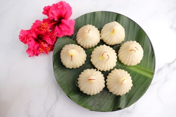 Steamed or ukdiche Modak. It's a traditional sweet dish made out of coconut, jaggery and dry fruits stuffed inside rice dough. Offered to Lord Ganesha during Ganpati festival in India. with copy space