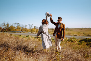 Young couple in love walking outdoors on a sunny day. The man gently hugs the woman. Love story. Autumn style.