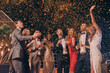 © gstockstudio - Group of beautiful people in formalwear having fun together with confetti flying all around