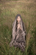 © Milou Dirks - conceptual art portrait of asian girl sitting in a field of grass covered by thin shiny fabric