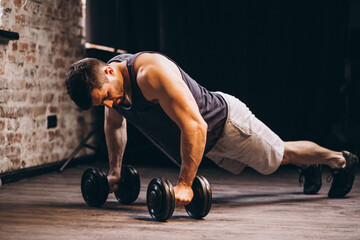 fit man doing push ups with dumbbells