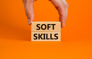 Soft skills symbol. Concept words 'Soft skills' on wooden blocks on a beautiful orange background. Businessman hand. Business, educational and soft skills concept, copy space.