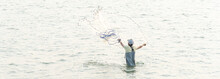 Panoramic Rear View Asian Fisher Man With Waterproof Wader And Hat Throwing A Cast Net In Freshwater Fishing