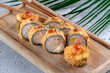 Japanese sushi tempura maki made of crab meat and avocado with a crispy crust. Japanese dish with hot sauce and shrimp