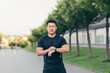 © Liubomir - Male asian athlete, tired after a morning jog, runs in the park near the stadium