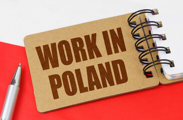 On the flag of Poland lies a notebook with the inscription - Work in Poland