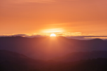 Wall Mural - Beautiful sunrise. Sun rays enlighten the meadow with trees. Spring morning. Landscape with high mountains. Panoramic view. Natural scenery. Wallpaper background. Touristic place Carpathian park.