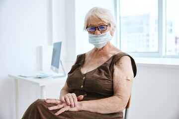 elderly woman wearing glasses medical mask hospital vaccine passport