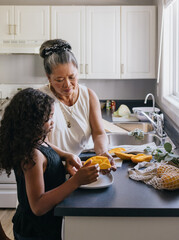 Asian grandmother cutting Filipino mango with grandchild