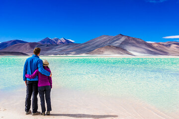 Couple enjoying view on Laguna Salar de Talar with the Andes Mountain, San Pedro de Atacama, Chile