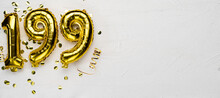 Golden Foil Balloon Number One Hundred Ninety Nine. Birthday Or Anniversary Card With The Inscription 199. Gray Concrete Background.