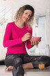 © JeanPaul - Young adult woman sitting on table holding bowl and spoon having breakfast