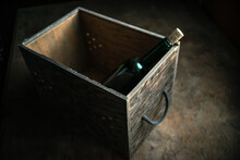 An Old Wooden Wine Box With A Vintage Wine Bottle In An Old Basement On A Wooden Table. Photo In Retro Style.
