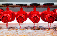 Four Red Fire Hydrants On A Fire Line On A Ship.