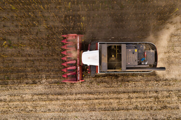 Sticker - Combine harvester harvesting sunflower field at sunset. Aerial drone point of view.