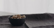 salted pistachios in black bowl on linen cloth