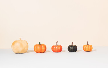 Creative autumn layout made with colorful pumpkins on beige background with copy space. Halloween nature concept. Modern aesthetic.