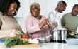 © Alessandro Biascioli - Happy African family having fun in modern kitchen preparing food recipe with fresh vegetables - Food and parents unity concept