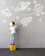 © Igor Yaruta - Happy kid draws a chalk rocket on the wall