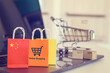 Online shopping, home shopping or product ordering, ecommerce concept : Flag of China, shopping bag with a shopping cart on a laptop keyboard, depicting buyer buys goods or services via the internet