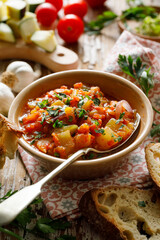 Wall Mural - Vegan zucchini and pumpkin stew with the addition of tomatoes and herbs in a bowl, close up view. Healthy and nutritious meal 