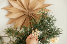 Hand Holding Stylish Christmas Star Straw Ornament On Pine Branches In Vase On Background Sweden Star In Festive Decorated Scandinavian Room. Eco Plastic Free Decorations. Happy Holidays
