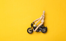 Wooden Puppet On Motorcycle On Yellow Background