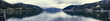 Zell am See. Zdjęcie panoramiczne na jezioro zrobione z pomostu. Wieczór z duża ilością chmur. Późne lato. W tle widać Alpy - Wysokie Taury.