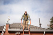 Solar panel installation worker on roof of house