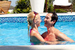 © Cultura Allies - Mid adult couple in outdoor pool, laughing