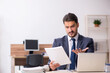 © Elnur - Young male employee sitting at workplace