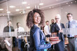 © Image Source Limited - Portrait of young businesswoman carrying celebration cake into boardroom
