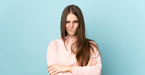 Wall Mural - Young caucasian woman isolated on blue background with unhappy expression